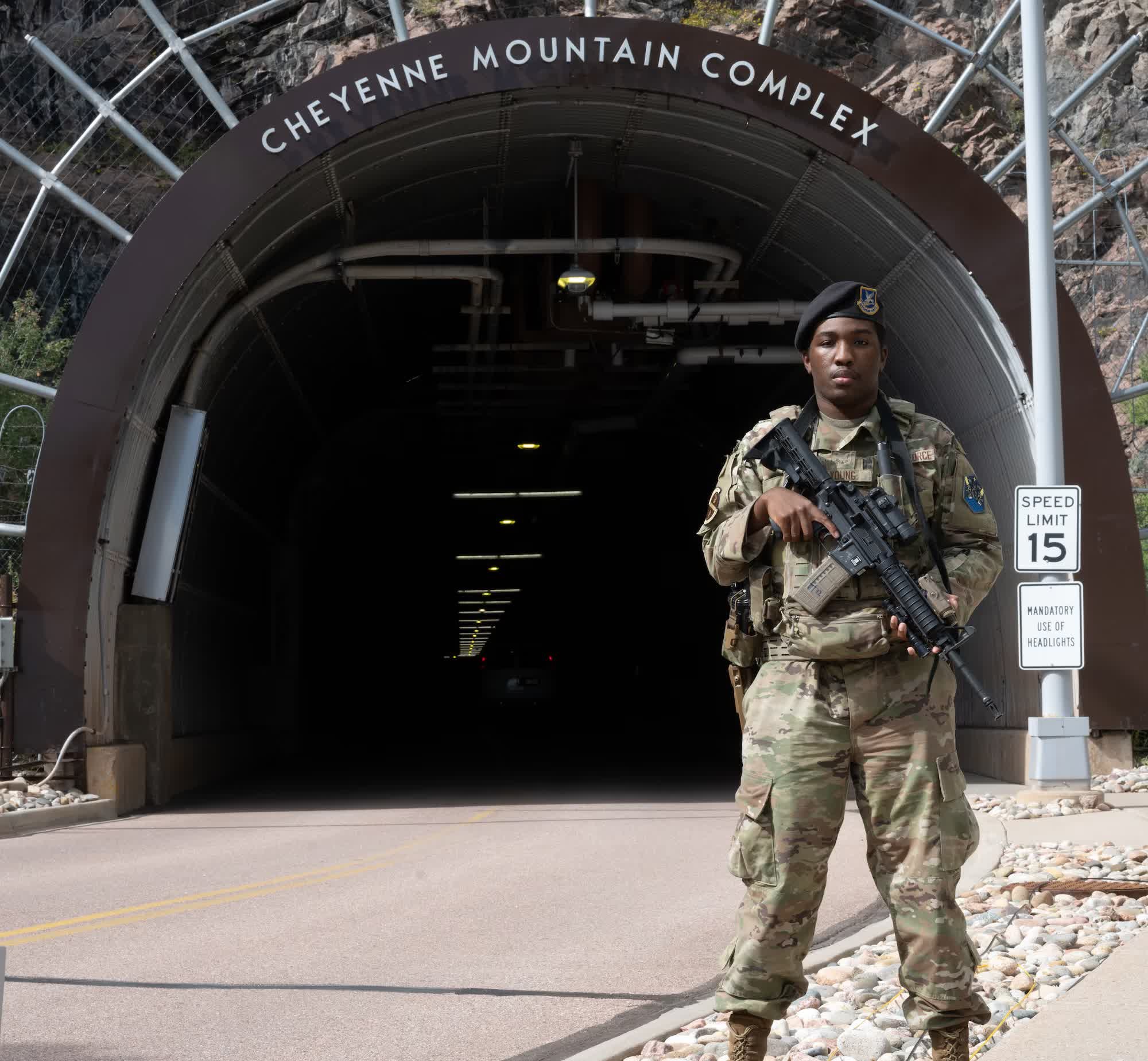 Airman standing in front of the Cheyenne Mountain Complex portal arch