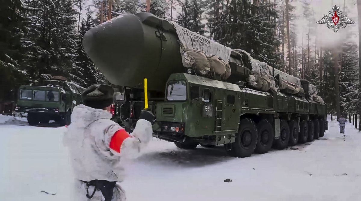 RS-24 Yars TEL in snow with soldier signaling